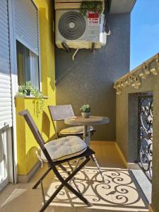 a chair and a table on a balcony with a microwave at Olea relax apartman in Brčko