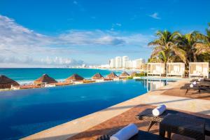 a swimming pool with a view of the ocean at Krystal Grand Cancun All Inclusive in Cancún