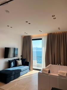 a living room with a blue couch and a tub at Blue Waves Hotel & Suites in Sarandë