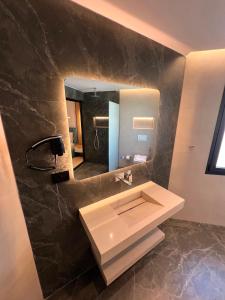 a bathroom with a sink and a mirror at Blue Waves Hotel & Suites in Sarandë +68 photos