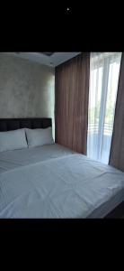 a bedroom with a white bed with a window at melvina LUX in Pančevo