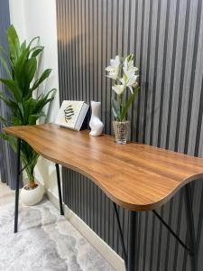 a wooden table with flowers and a book on it at شقه in Ar Rass