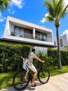 a man riding a bike in front of a house at Vip villa in Phú Quốc