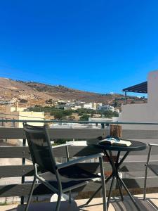 a table and a chair sitting on a balcony at Alegria Suite in Ermoupoli