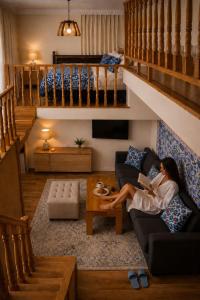a woman sitting on a couch in a living room at Chorminor 1 min to Bukhara Old Town GET EARLY CHECK IN AND LATE CHECK OUT in Bukhara