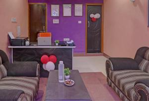 a living room with two couches and a purple door at Super Hotel O Surya Inn in Varanasi