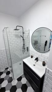 a bathroom with a sink and a shower with a mirror at Wodniak in Ostróda +23 photos
