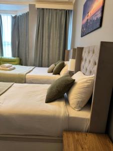 two beds in a hotel room with pillows on them at Regent Hotel in Eastbourne
