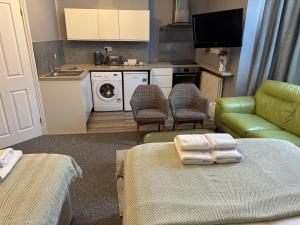a living room with a couch and a kitchen at Regent Hotel in Eastbourne