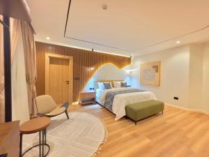 a bedroom with a bed and a table and a chair at Amazonia Luxury in Abuja
