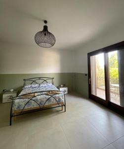 a bedroom with a bed and a window and a chandelier at Casa Manu in Gallipoli +11 photos