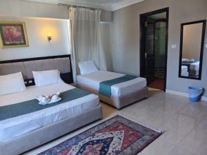 two beds in a hotel room with towels on them at DaVinCi hotel in Hurghada +44 photos