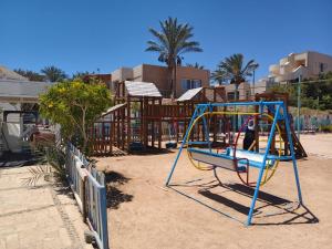 a playground with a swing set on the beach at DaVinCi hotel in Hurghada