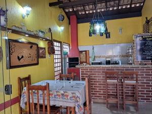 a dining room with a table and chairs and a kitchen at Espaço Gozzoli, Cantinho da Nonna in Espirito Santo Do Pinhal +7 photos