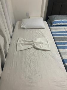 a bed with a bow tie on top of it at Apart - em frente á praia dos milionários- Ilhéus in Ilhéus +32 photos