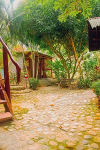 a garden with a house and trees and a stone patio at A-típico in Santa Marta
