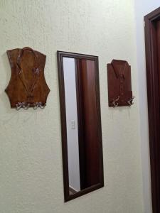 a mirror on a wall with a reflection of a brown umbrella at Espaço Gozzoli, Cantinho da Nonna in Espirito Santo Do Pinhal