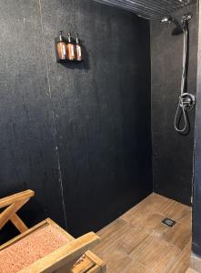 a room with a shower with a black wall at Loblolly Pines Adventure Aframe #1 in Eureka Springs