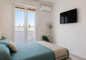 a bedroom with a bed and a tv and a window at Mellini Living in Misano Adriatico