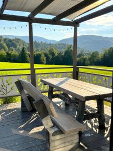 a wooden picnic table and bench sitting on a wooden deck at KORBIELOVKA domek z sauną in Korbielów