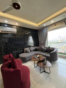 a living room with a couch and two chairs at ELYSIUM TOWER- One Bedroom Luxury Apartment With Balcony & City View OPP Centaurus Mall Islamabad in Islamabad