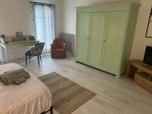 a bedroom with a bed and a cabinet and a desk at Sérénité in Saint-Vivien-de-Blaye