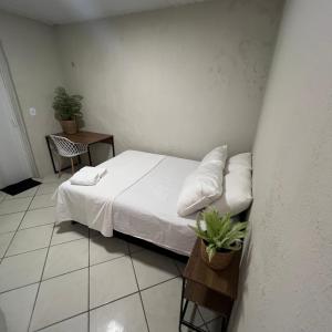 a bedroom with a bed with white sheets and pillows at Brisa Mar in Fortaleza +1 photo