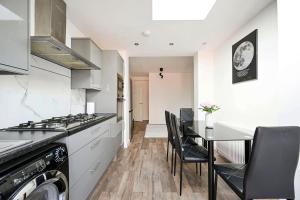 a kitchen with a stove and a table with chairs at Two bedrooms apartment in Wainscot +26 photos