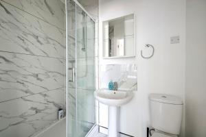 a white bathroom with a sink and a shower at Two bedrooms apartment in Wainscot