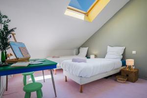 a room with two beds and a desk and a window at Monet Garden Retreat in Giverny