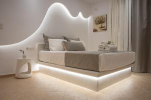 a bedroom with a bed with a lighted headboard at Aurora Horizon Naxos in Glinádhon