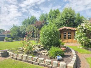 a garden with a flower bed and a house at Ferienwohnung Ufen in Hage