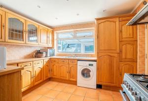 a kitchen with wooden cabinets and a washer and dryer at DD Private Double Room with Shared Bathroom in York