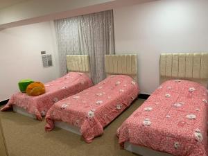 a bedroom with two beds with pink sheets and a teddy bear on top at Sulav amedi in Sūlav