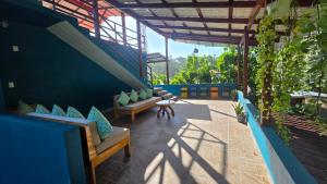 a patio with couches and a table and some plants at Alma Del Bosque Hotel in Tortuguero