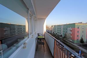 Przy Błoniach في شتتين: شرفة مع طاولة وكراسي ومباني