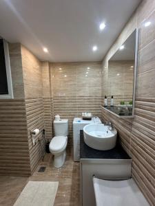 a bathroom with a toilet and a sink at Bright and Peaceful Apartment near Varkiza beach in Varkiza