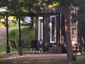 a porch of a house with chairs and a table at Forest house Maestral in Koper +11 photos