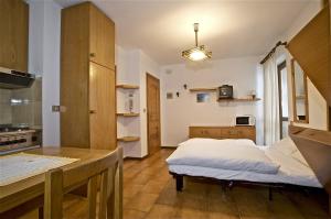 una piccola cucina con un letto in una camera di Residence Raffaella a Santa Caterina Valfurva