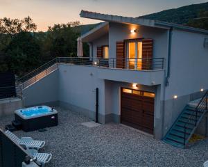 a house with a hot tub on a patio at Villa Omaha in Vekići