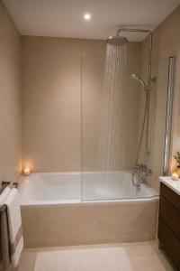 a bathroom with a bath tub with a shower at Royal Rif Tanger Marina Bay in Tangier +11 photos