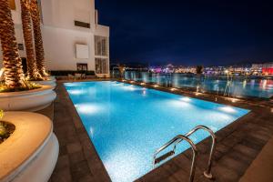 a large swimming pool with lights on a building at Royal Rif Tanger Marina Bay in Tangier
