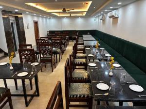 a dining room with tables and chairs in a restaurant at Taj Comfort Inn in Agra