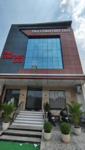 a building with two motorcycles parked in front of it at Taj Comfort Inn in Agra