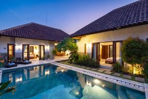 a villa with a swimming pool at night at Lapiz Lazuli in Seminyak