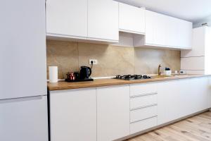 a white kitchen with white cabinets and a stove at Casa Agigea in Agigea