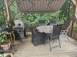 a patio with a table and chairs and a grill at Furubo in Orkelljunga +19 photos