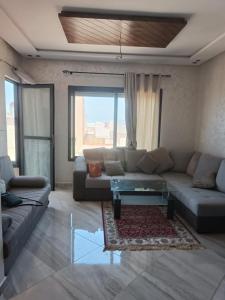 a living room with a couch and a coffee table at Mehdia Beach Apartment in Kenitra