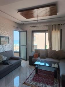 a living room with a couch and a table at Mehdia Beach Apartment in Kenitra