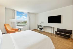 ein Hotelzimmer mit Bett, Schreibtisch und Fernseher in der Unterkunft Fiesta Inn Express Naucalpan in Mexiko-Stadt